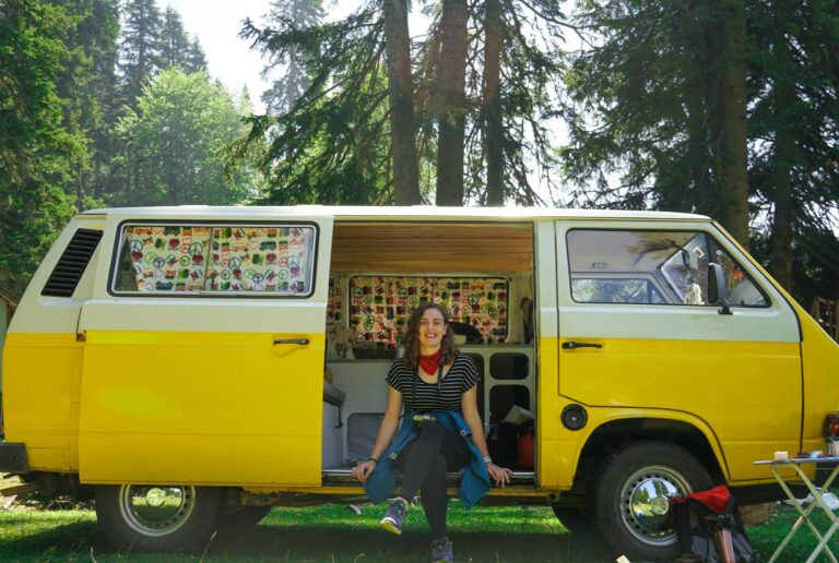 Woman in Black and White Shirt Sitting on Yellow Van