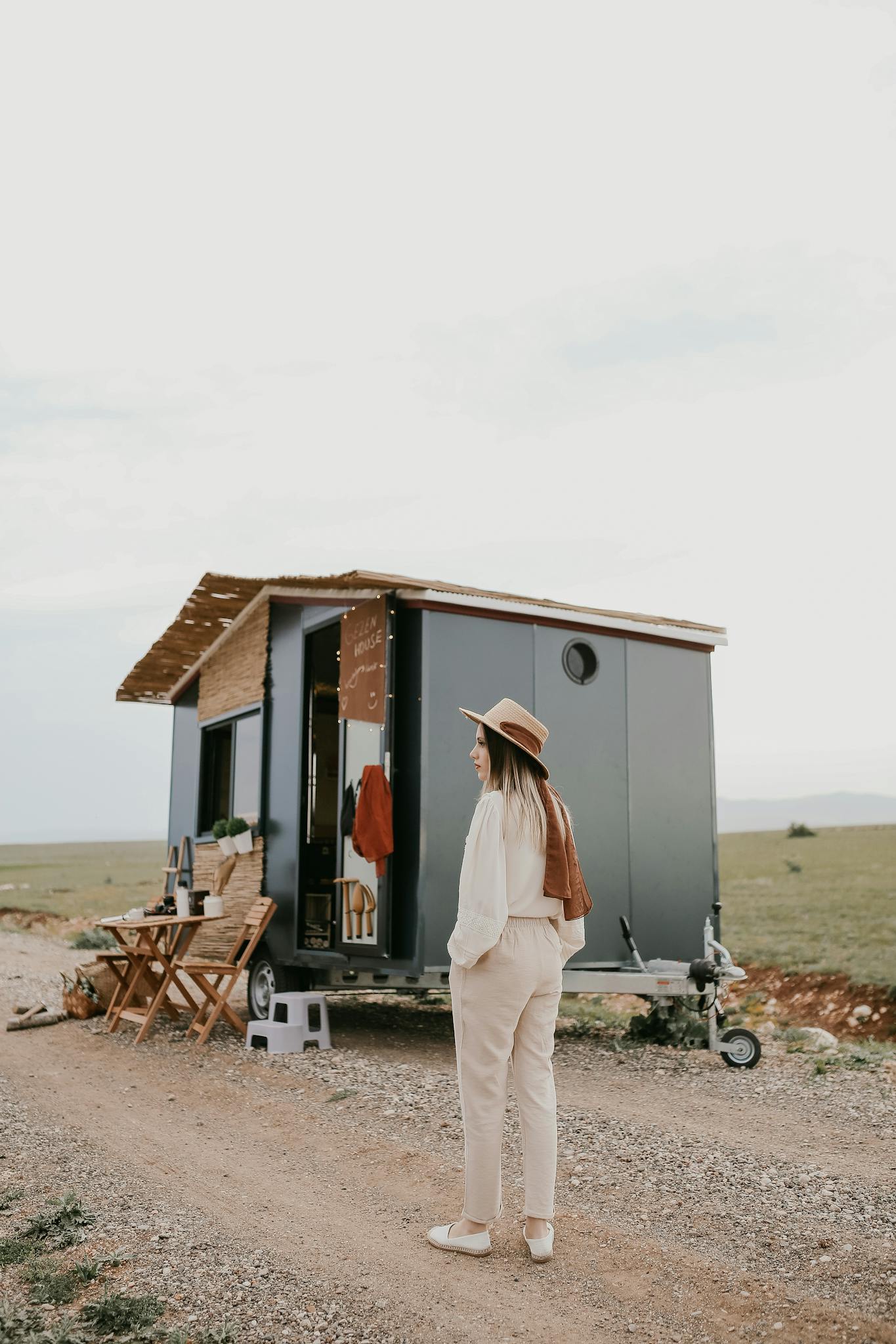 Woman Standing in front of a Trailer Converted to a House on Wheels